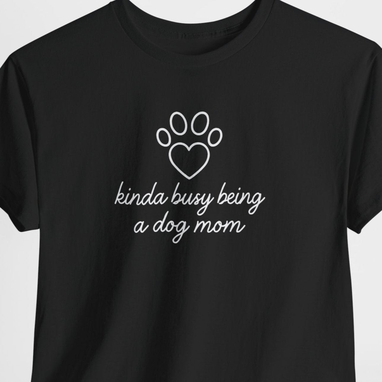 Black t-shirt with white text and paw print design on a light gray background