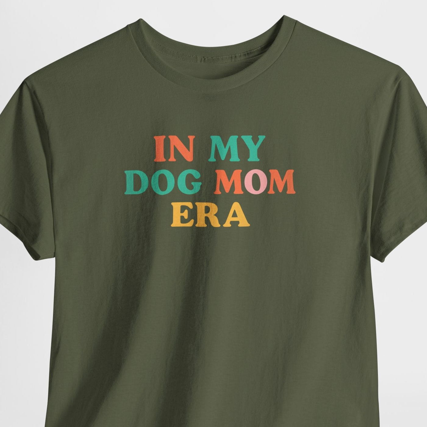 Green t-shirt with colorful text 'IN MY DOG MOM ERA' on a light gray background