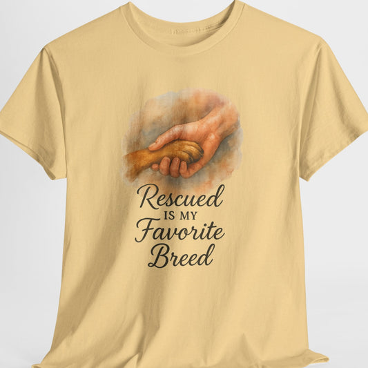 Beige t-shirt with a graphic of hands holding a dog and text 'Rescued is my Favorite Breed' on a light gray background