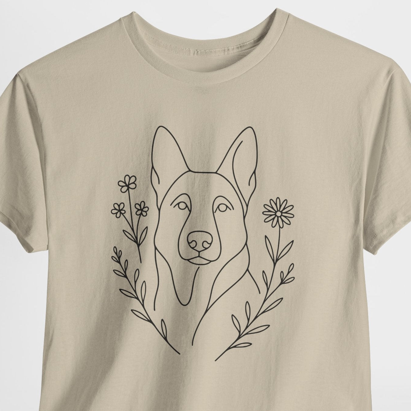 Beige t-shirt with a black line drawing of a dog's face and flowers on a white background