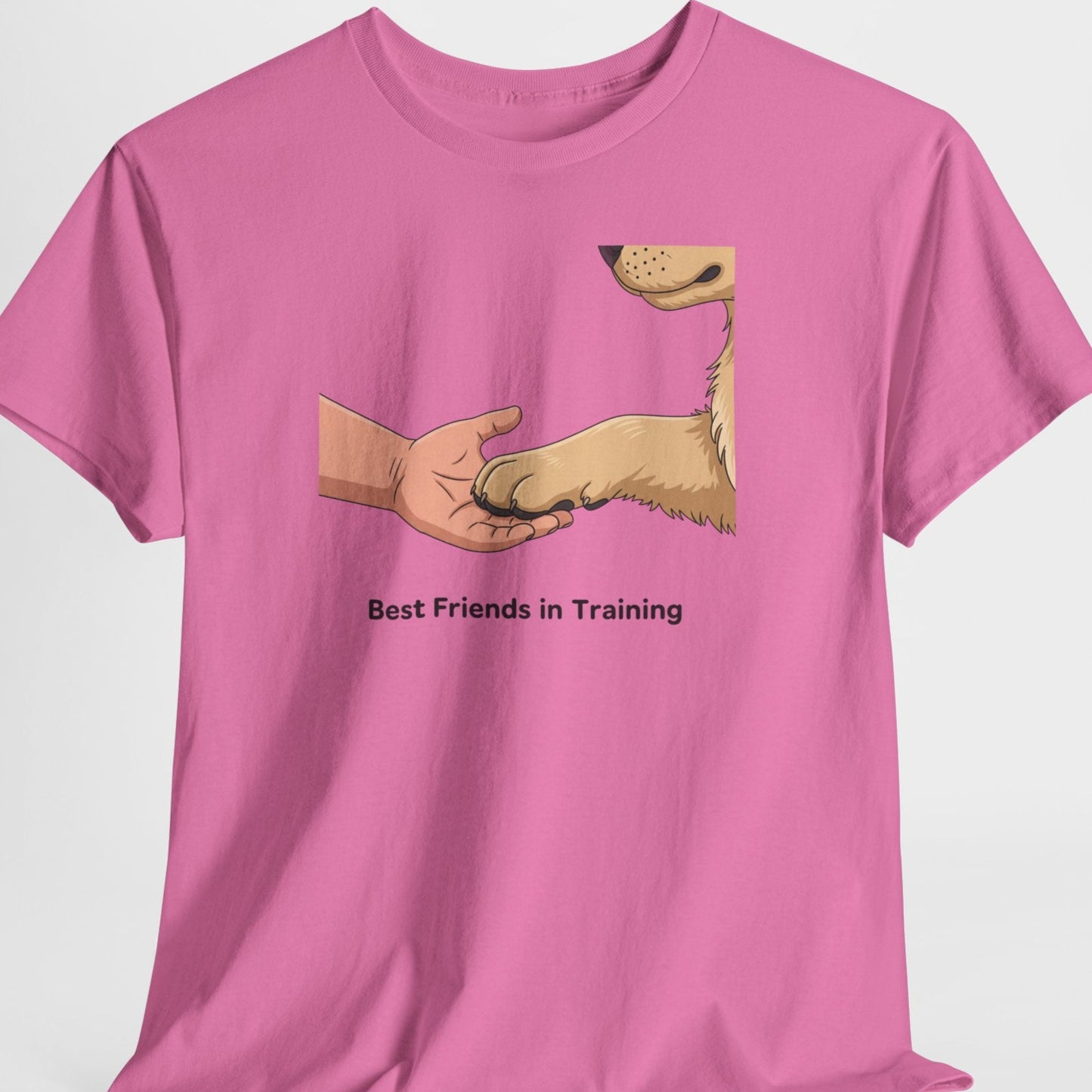 Pink t-shirt with a graphic of a hand shaking a dog's paw and text 'Best Friends in Training' on a white background.