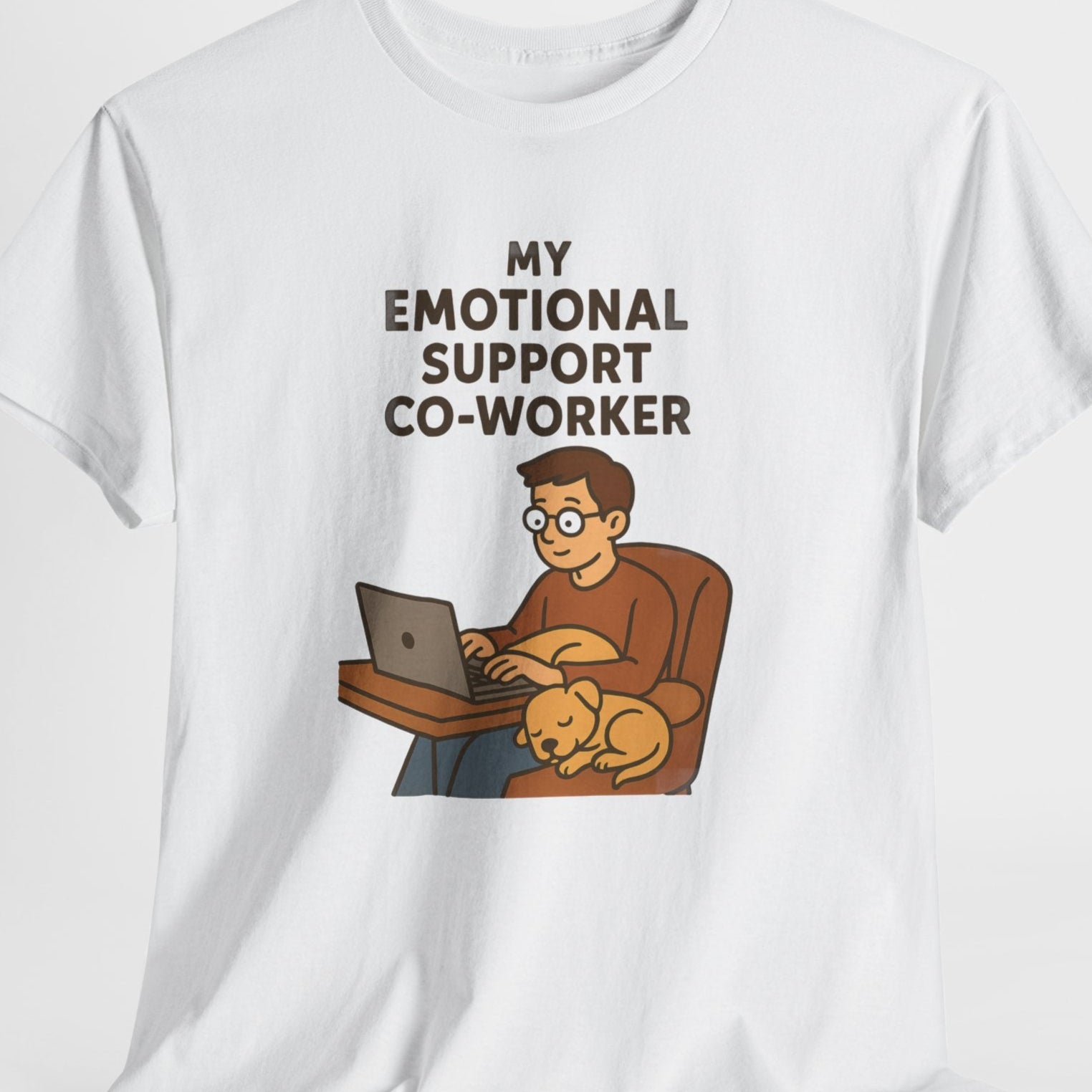 White t-shirt with a graphic of a person working on a laptop with a dog, and text 'My Emotional Support Co-Worker' on a white background.