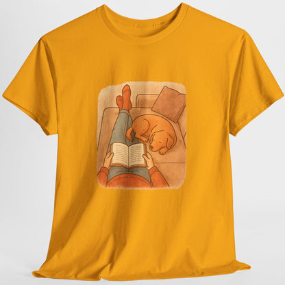 Yellow t-shirt with a graphic of a person reading a book to a dog on a white background