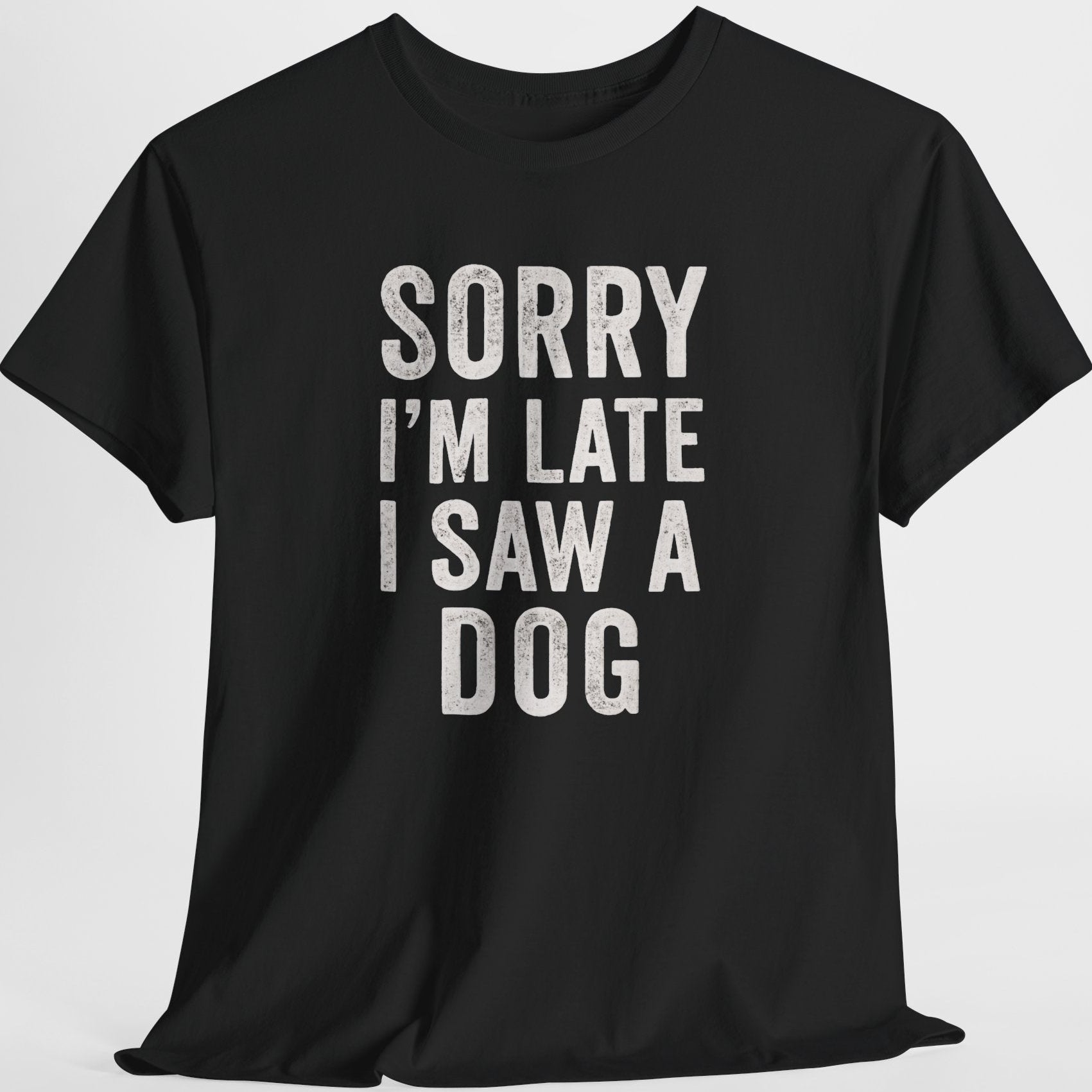 Black t-shirt with white text 'Sorry I'm late I saw a dog' on a light gray background